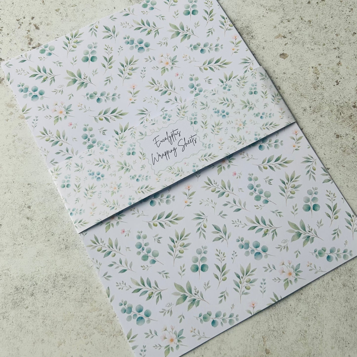 Floral patterned A4 wrapping sheets on a concrete surface