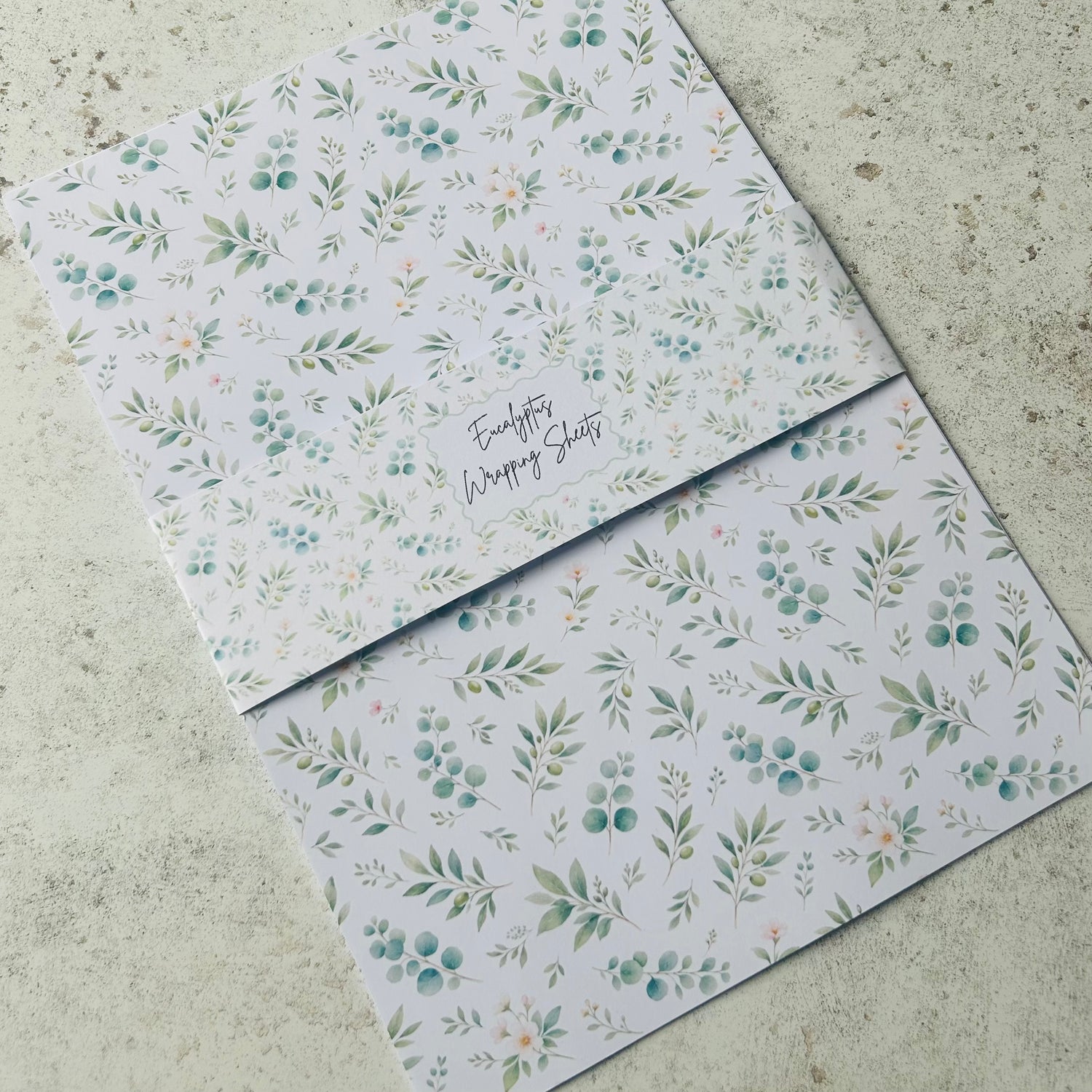Floral patterned A4 wrapping sheets on a concrete surface