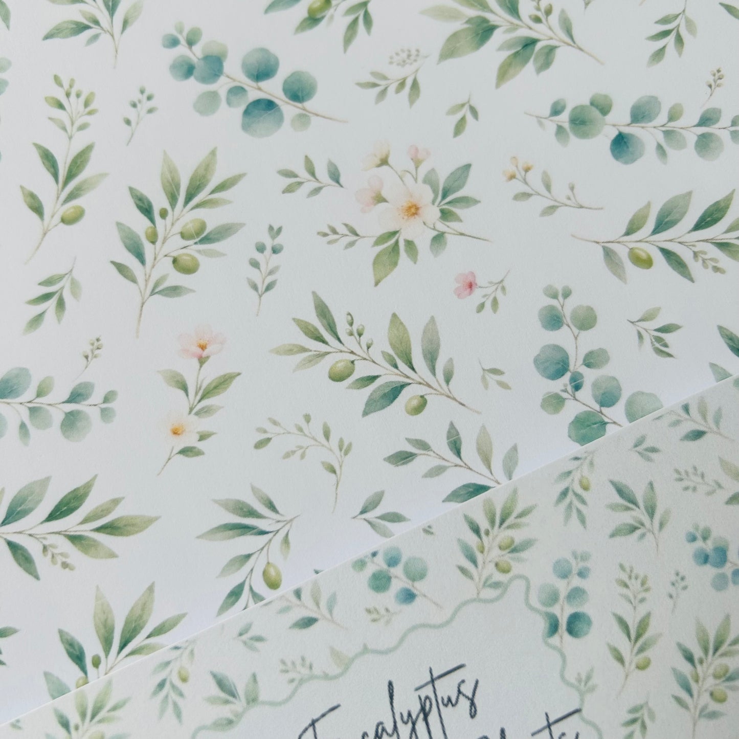 Pattern of green leaves and flowers on a light blue background