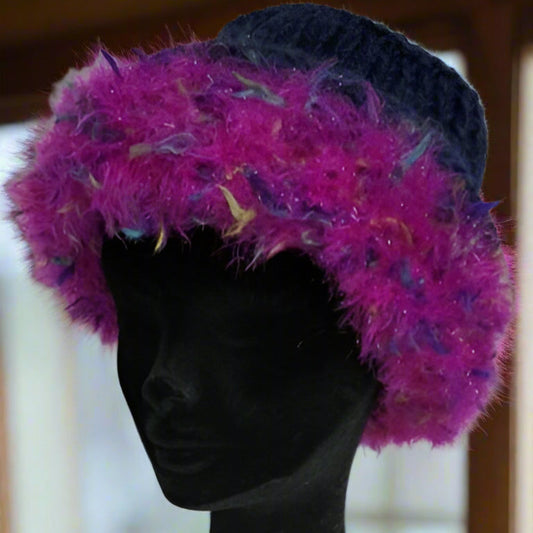 Purple feathered brimmed hat on a black mannequin head against a blurred background