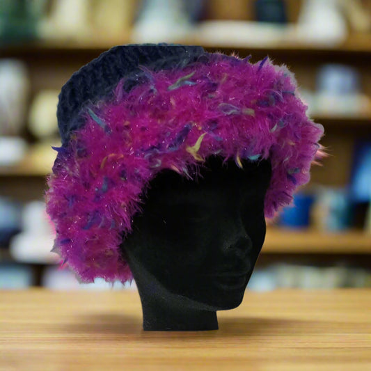 Mannequin head wearing a colorful feathered brim hat with dark top in a shop background