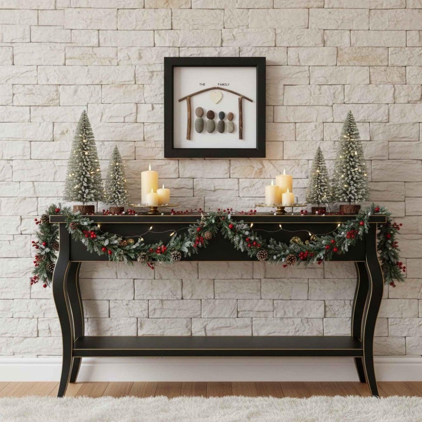 Black frame family pebble art above a black console table with Christmas decorations.
