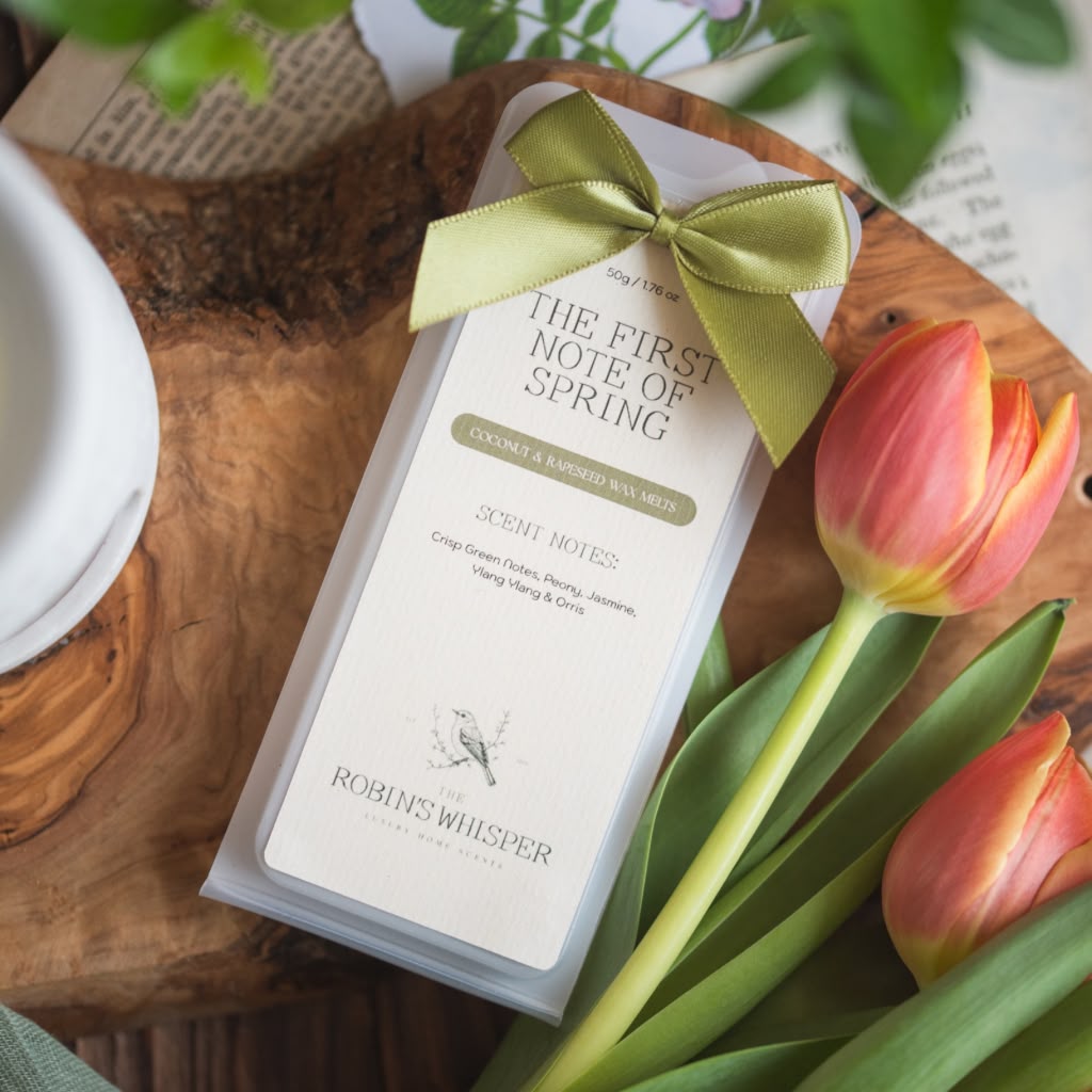 Product packaging of wax melts with a green bow and tulips on a wooden surface