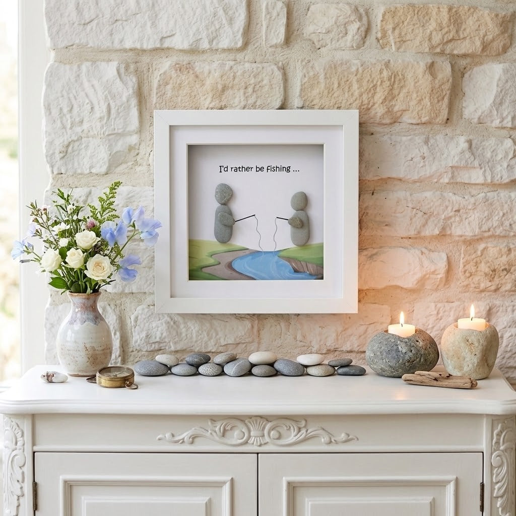 A framed art print featuring a minimalist fishing scene with stacked stones and the text 'I'd rather be Fishing.