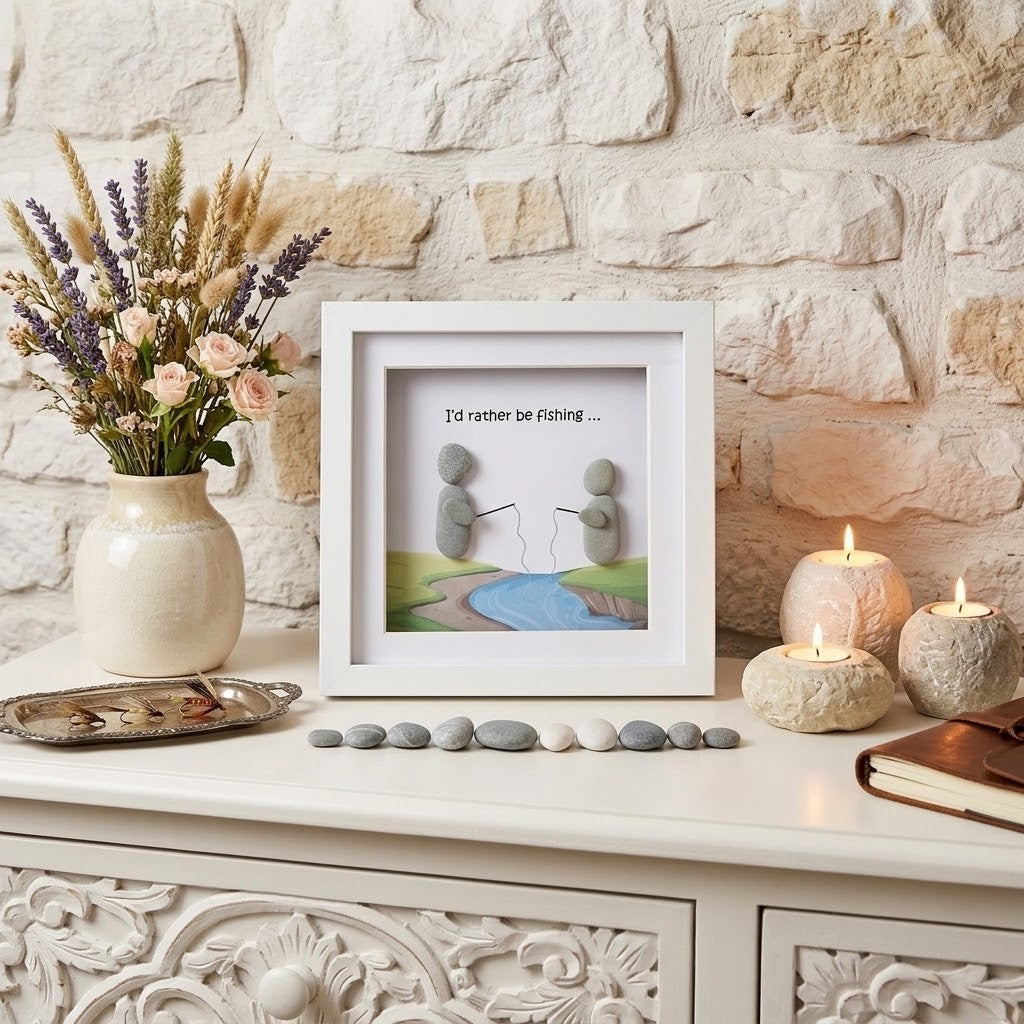 A framed art print featuring two stacked stones on a river with the text 'I'd rather be Fishing.