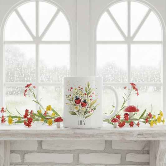 Ceramic mug with floral ladybird design and 'LILY' branding on a windowsill.