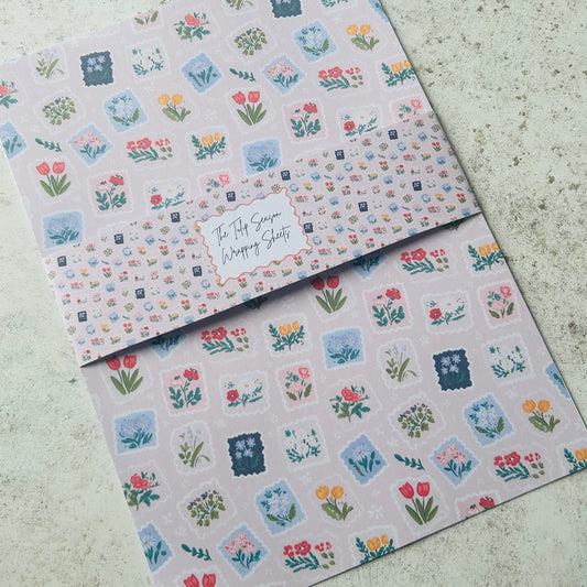 Two sheets of floral patterned paper on a textured surface