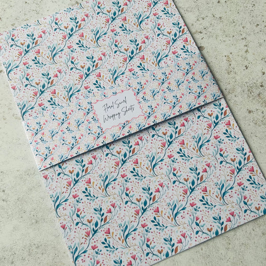 Floral patterned A4 wrapping paper sheets on a concrete surface