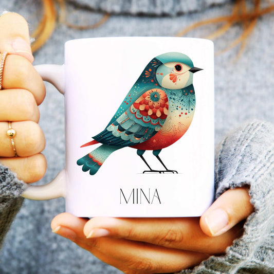 Mug with a colourful bird design held by hands
