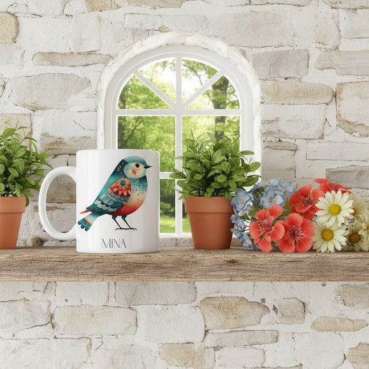 Mug with a bird design on a wooden shelf against a stone wall with a window.