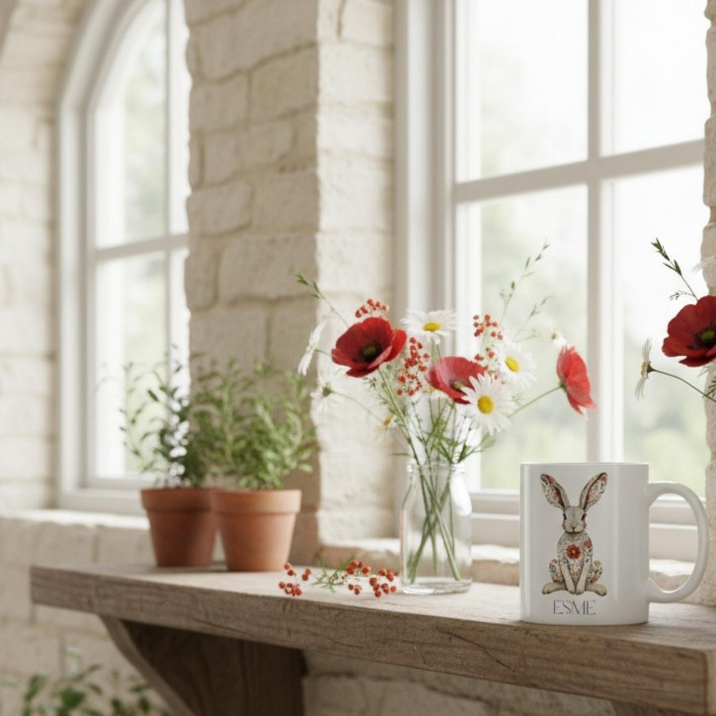 Mug with a hare design on a wooden table with flowers and plants in a bright room.