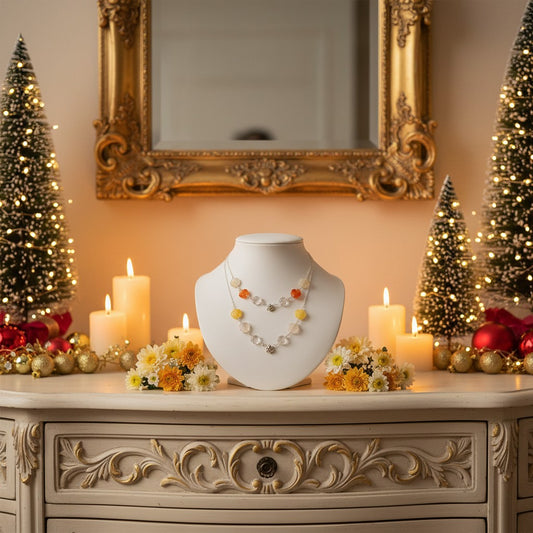 Lifestyle image of pretty gemstone necklaces on a necklace holder with candles, flowers and festive decorations.