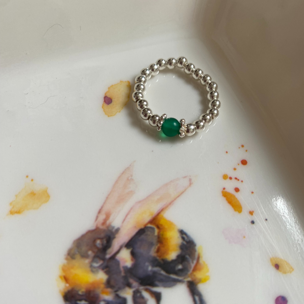 Green agate ring shown in a bumble bee ceramic dish