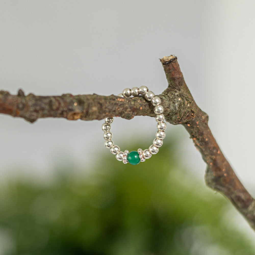 Green agate ring handing on a branch