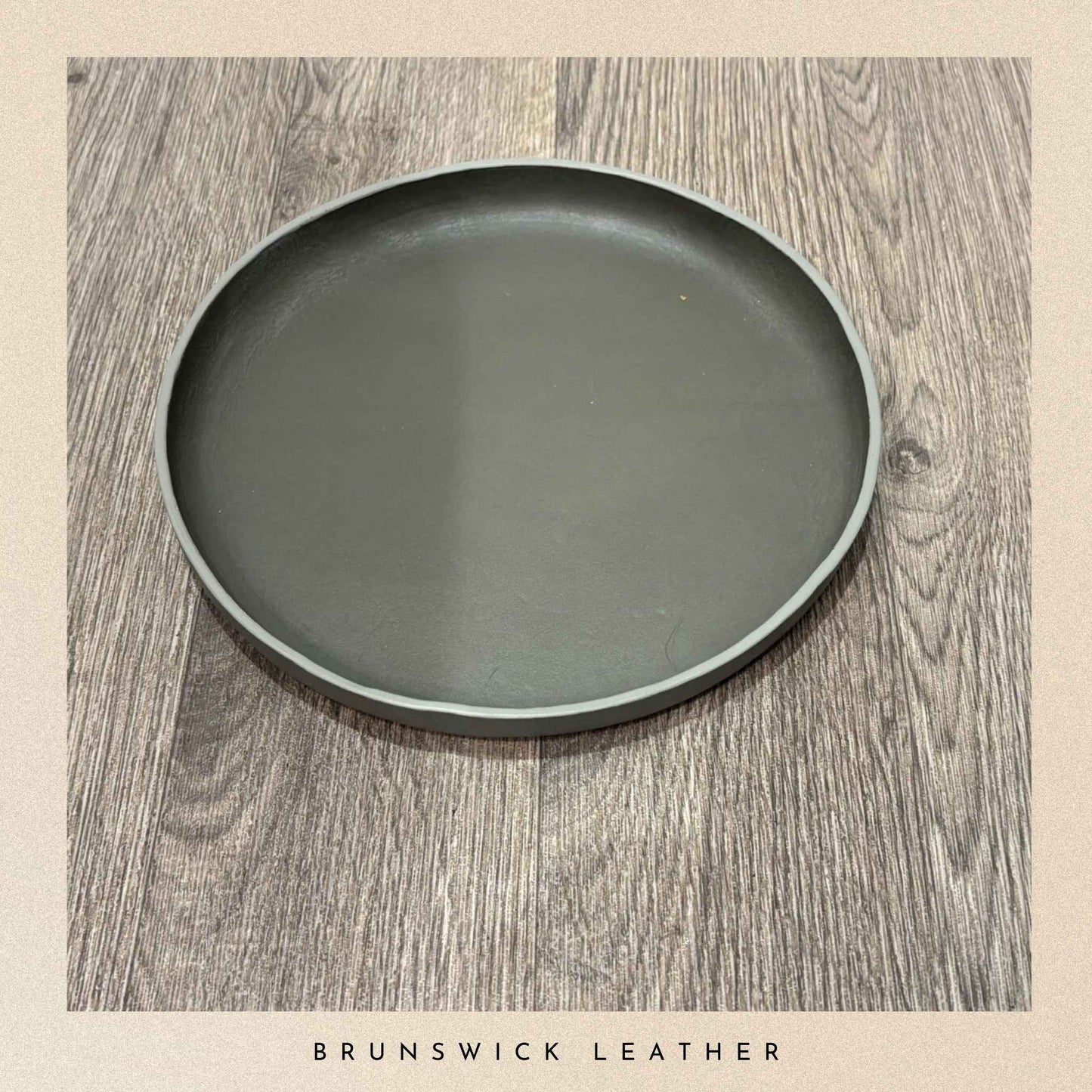 Dark grey leather-bound tray on a wooden surface with 'Brunswick Leather' branding.