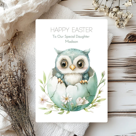 Easter card with an owl design and personalised text on a wooden surface.