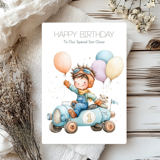 handmade card for son personalised with a boy in a race car with the number 1 on and balloons.