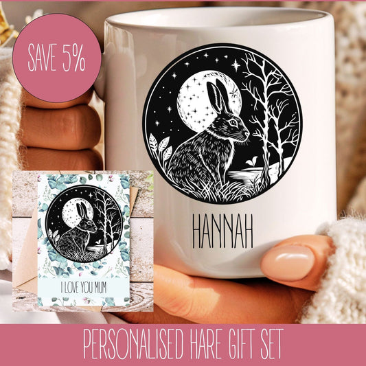 A personalised gift set featuring a white mug with a black illustration of a hare and surrounding foliage, and a matching A5 greeting card with the text 'Hannah' printed on it.