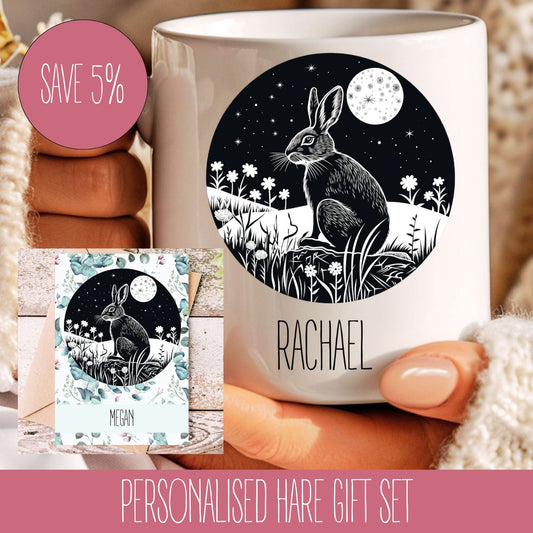 A personalised gift set featuring a white mug with a black and white illustration of a hare, moon, and stars, and a matching A5 card with the name 'Rachael' printed on it.