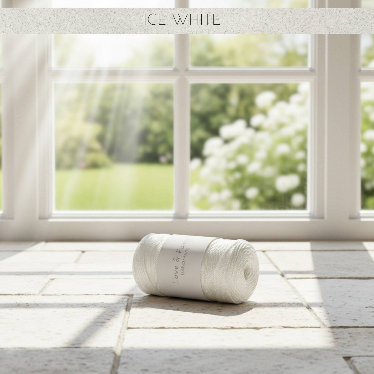 Roll of white yarn on a wooden floor with a window in the background