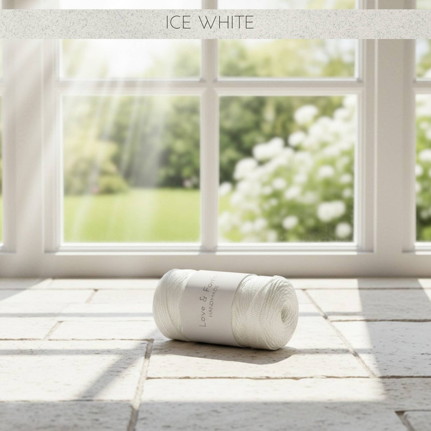 Roll of white yarn on a wooden floor with a window in the background