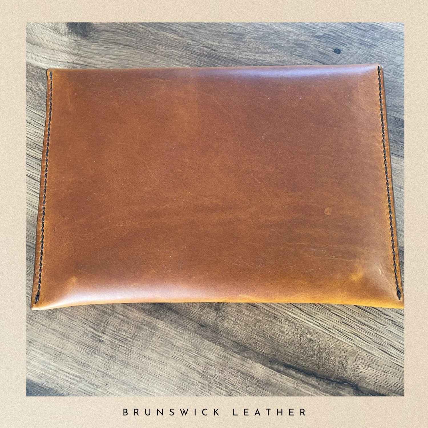 Brown leather pouch on a wooden surface with 'Brunswick Leather' branding.