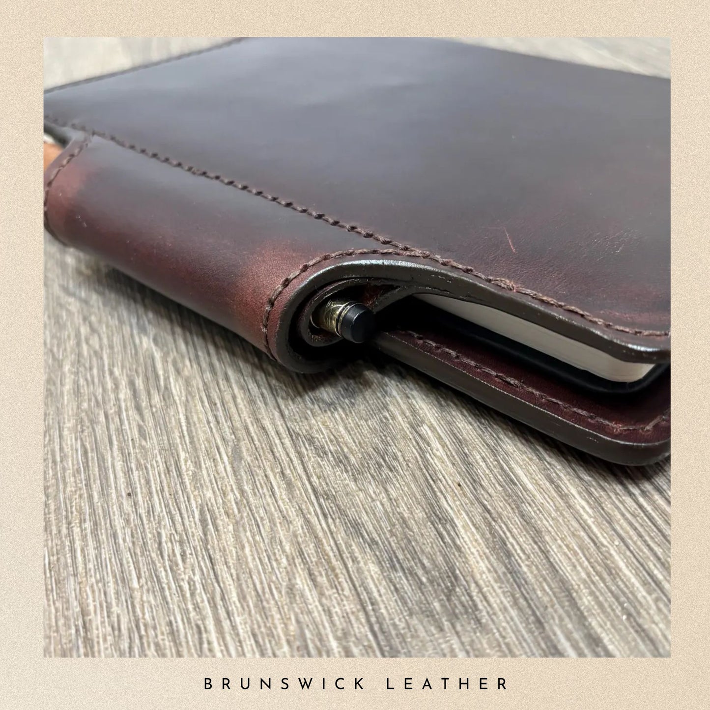 Brown leather wallet on a wooden surface with 'Brunswick Leather' branding.