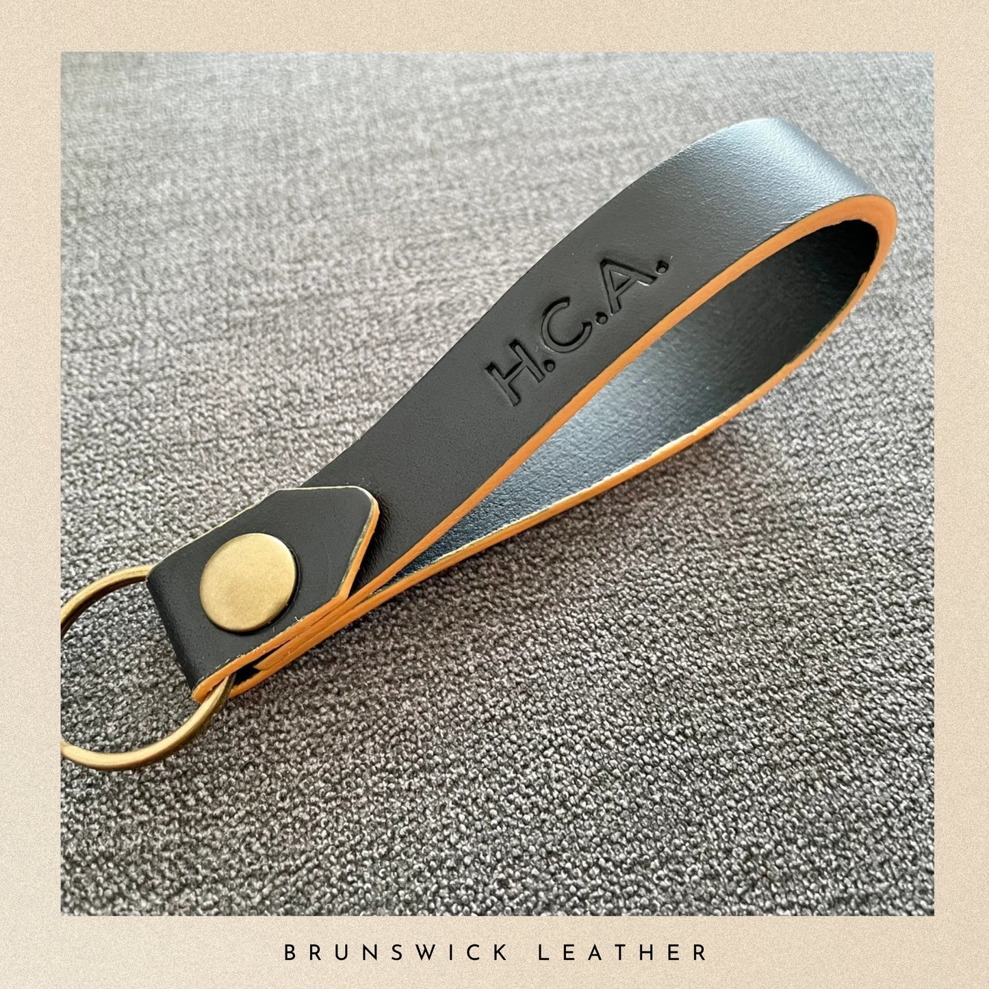 Leather keychain with 'H.C.A' engraving on a textured surface, branded 'Brunswick Leather'.