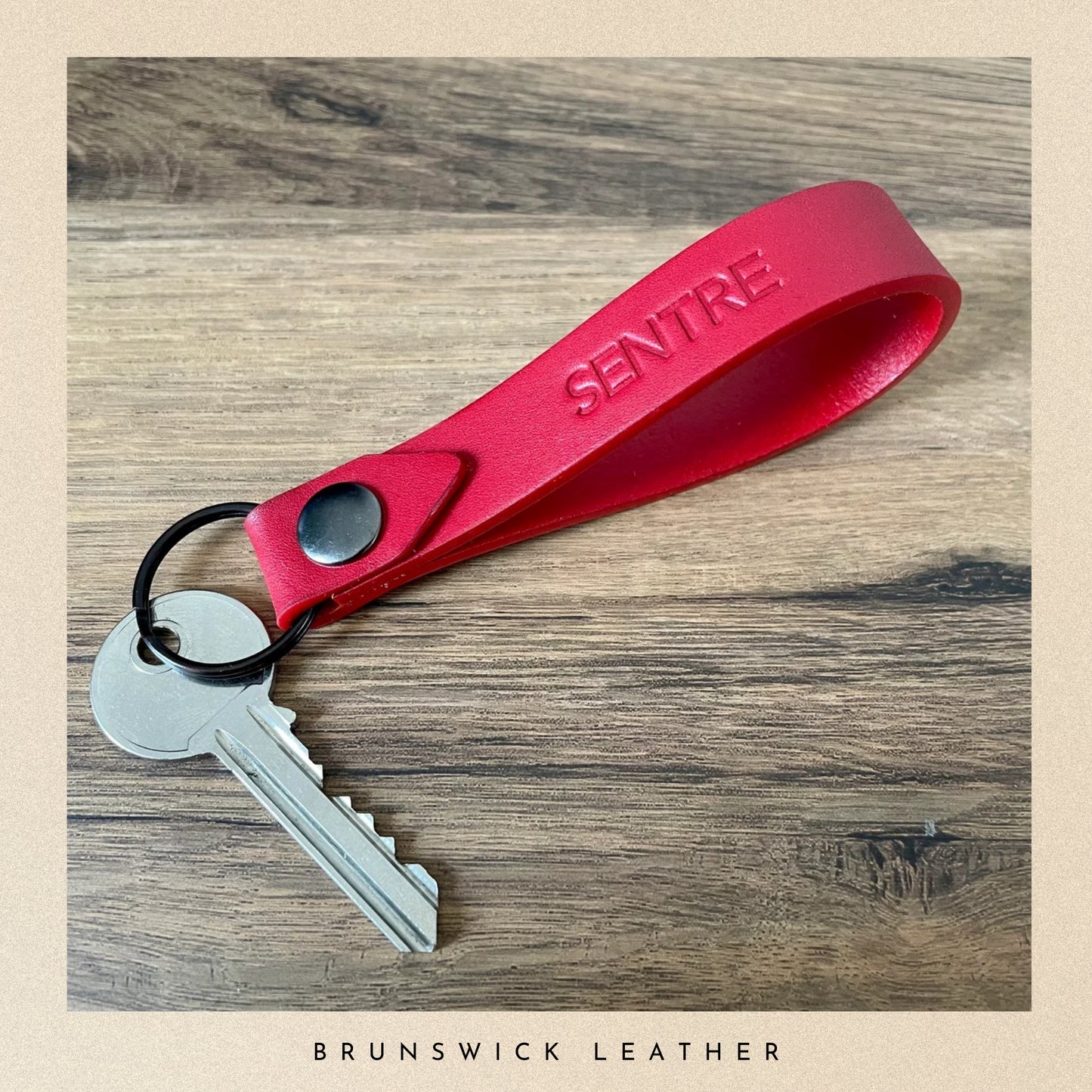 personalised leather keyring with a key and resting on a tabl.