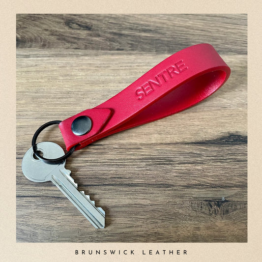 personalised leather keyring with a key and resting on a tabl.