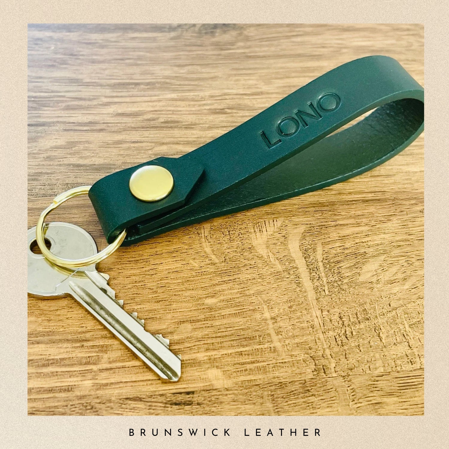 Green leather keychain with keys on a wooden surface, branded 'Lono'.