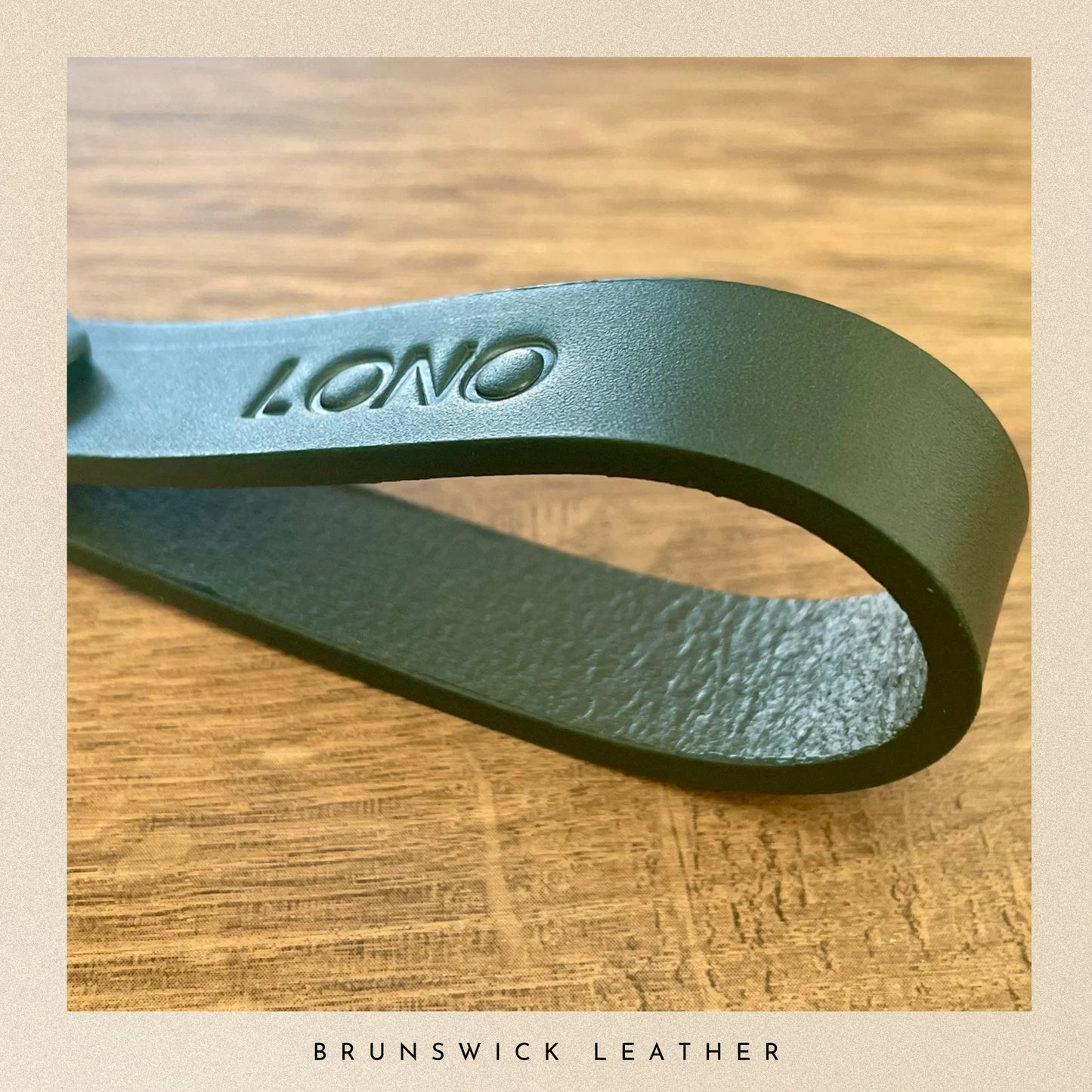 Green leather strap with 'Lono' branding on a wooden surface