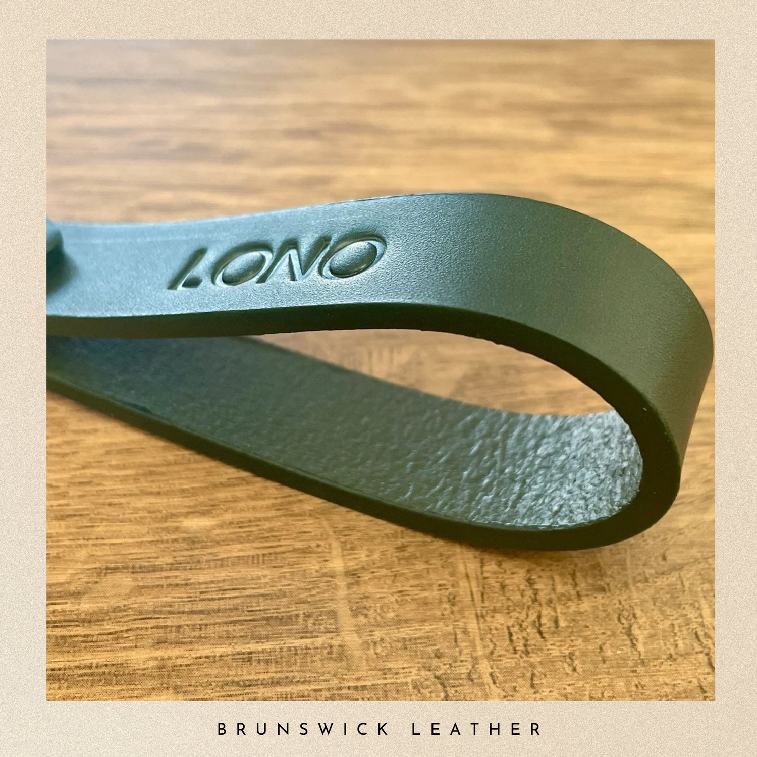 Green leather strap with 'Lono' branding on a wooden surface