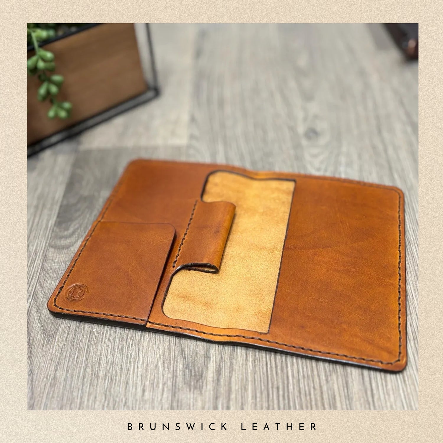Brown leather wallet on a wooden surface with 'Brunswick Leather' branding.