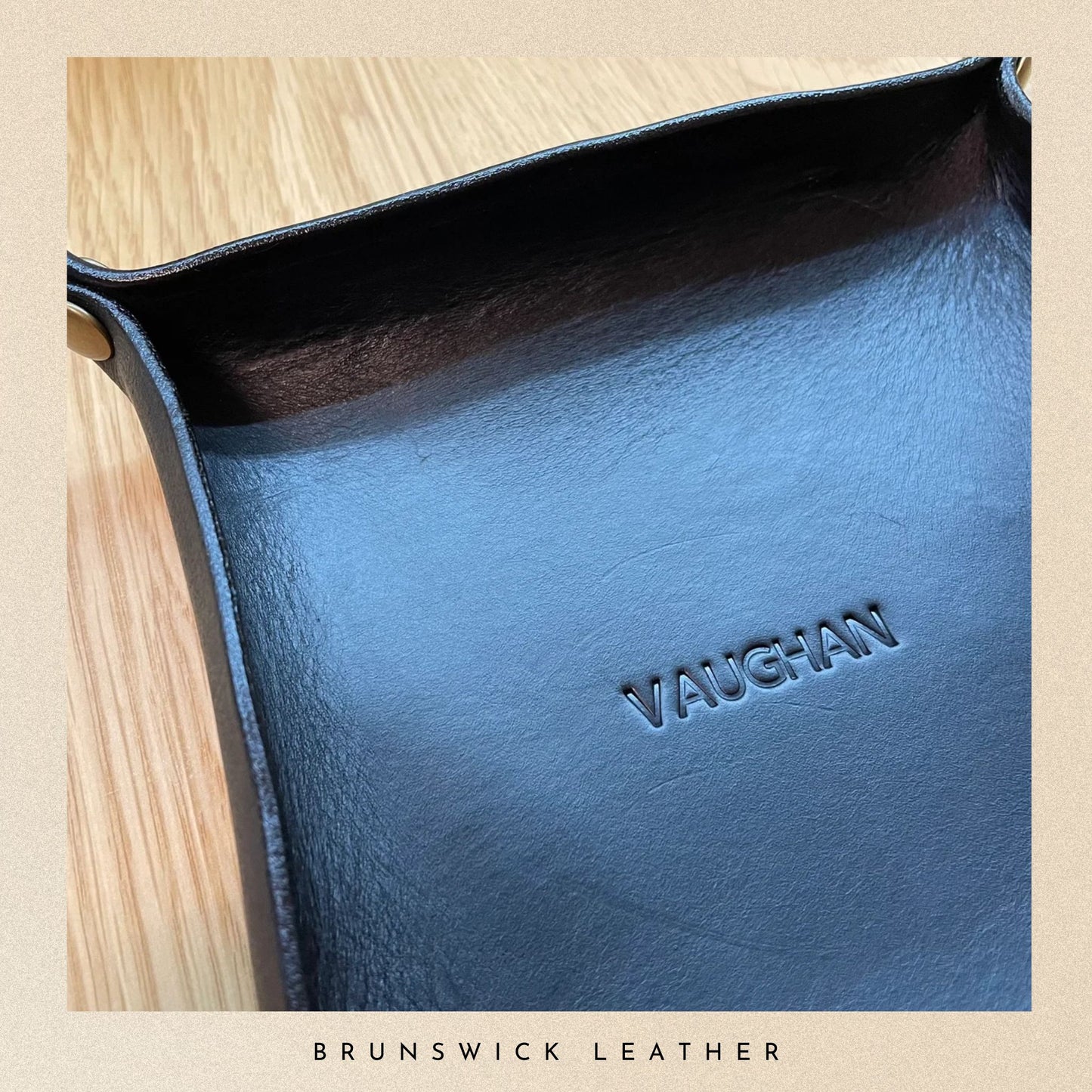 Blue leather product with 'VAUGHAN' branding on a wooden surface