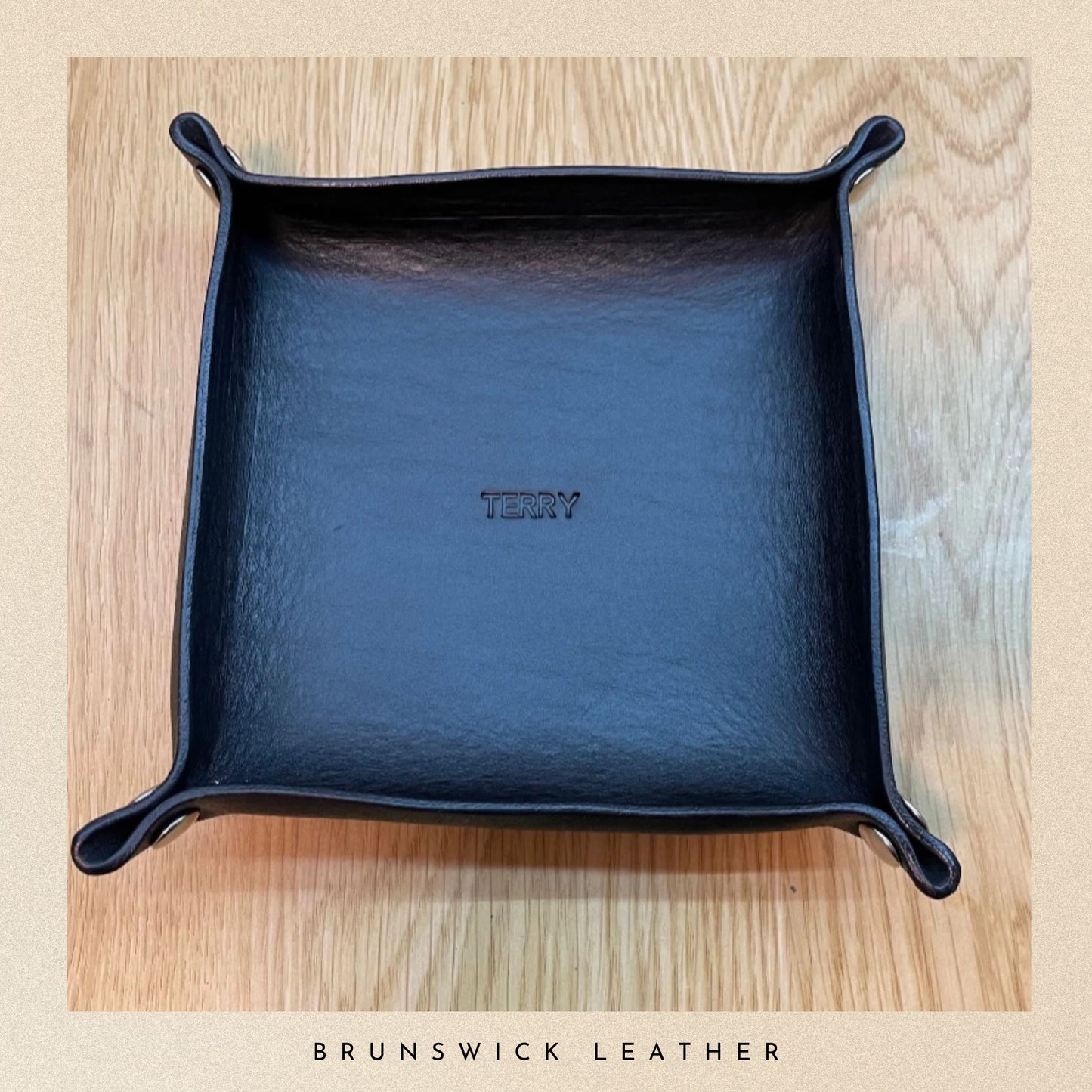 Blue leather tray with 'Terry' branding on a wooden surface, featuring Brunswick Leather.