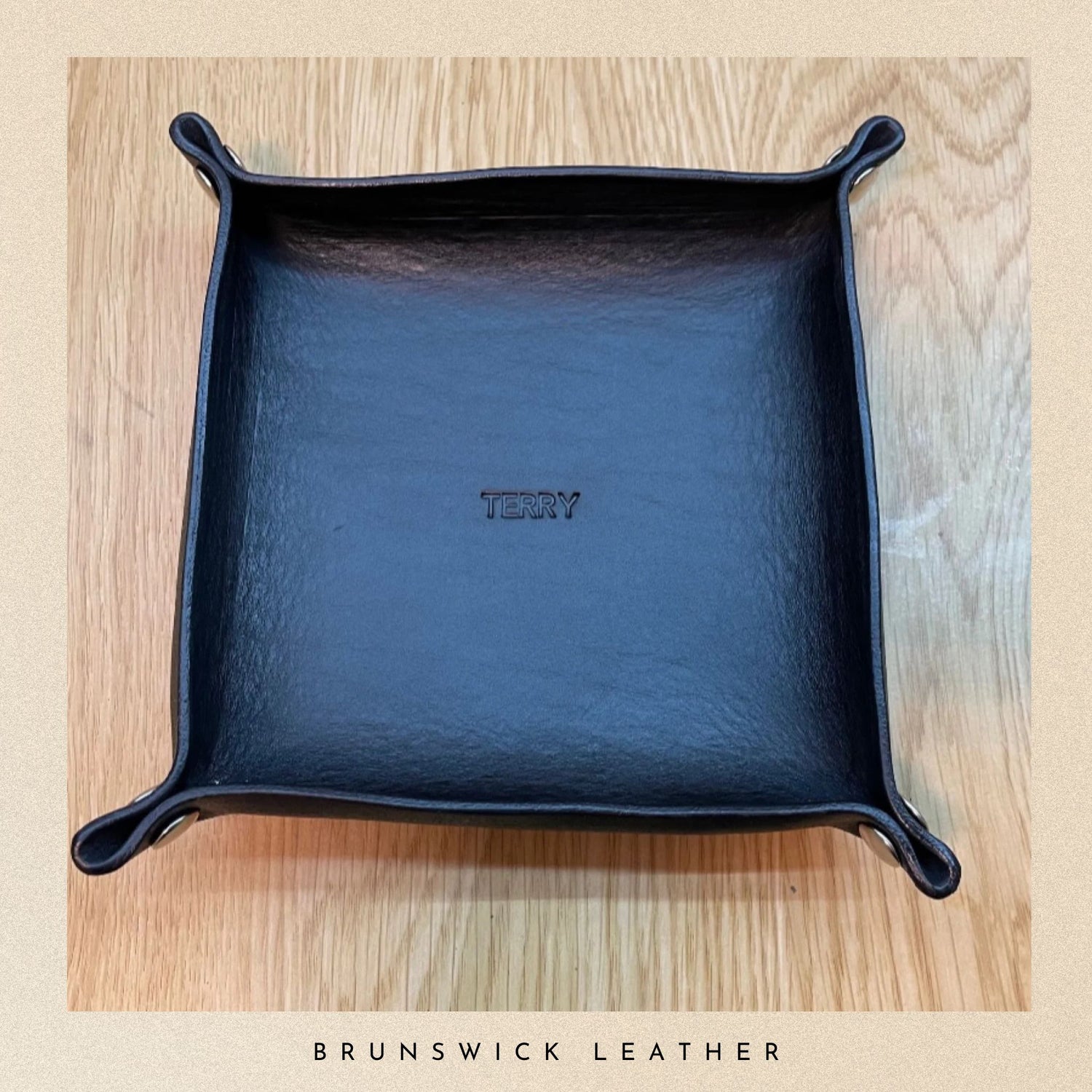 Blue leather tray with 'Terry' branding on a wooden surface, featuring Brunswick Leather.