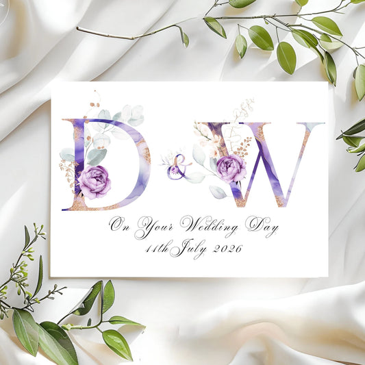 Wedding card with floral design and personalized text on a white fabric background.