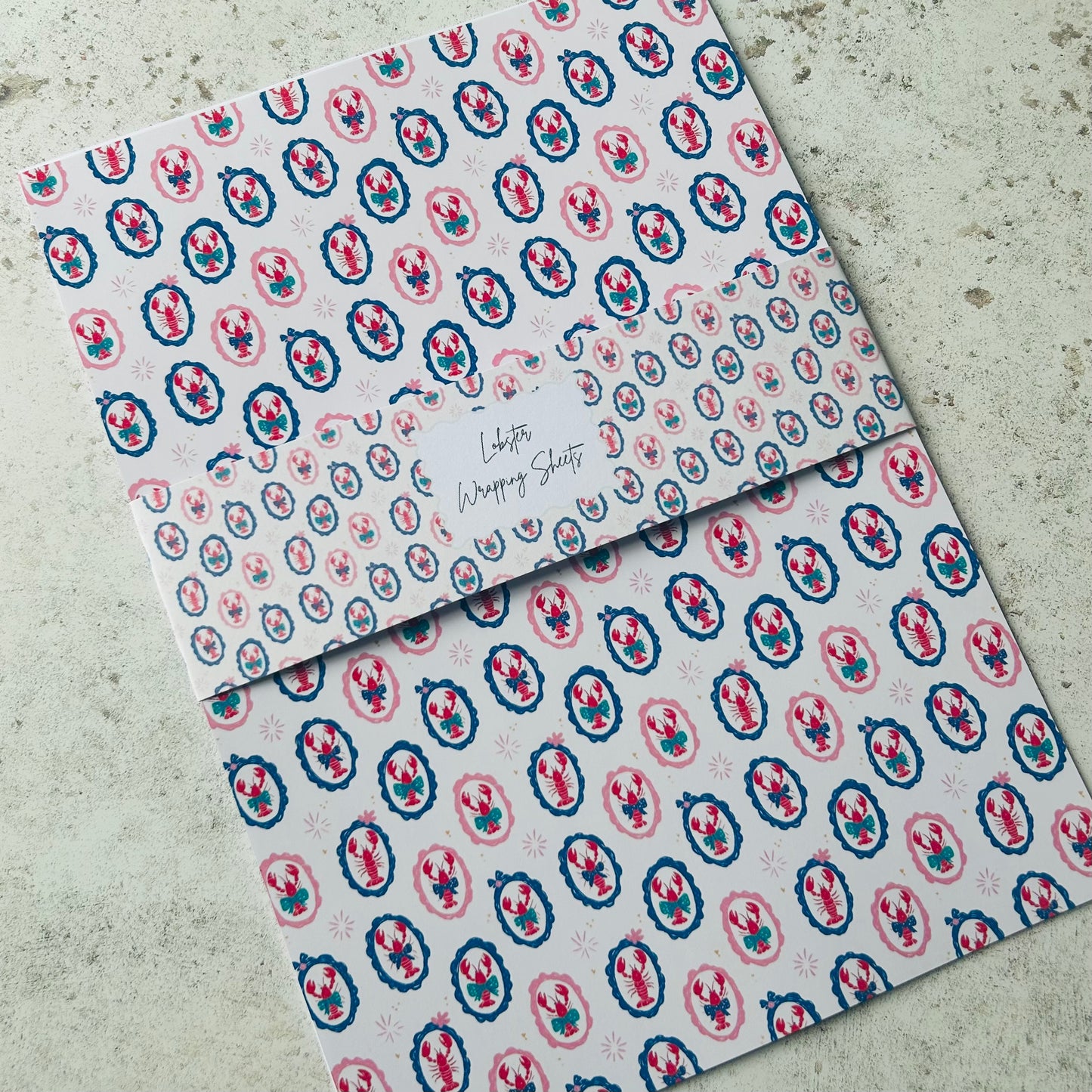 Two patterned lobster a4 sheets on a textured surface