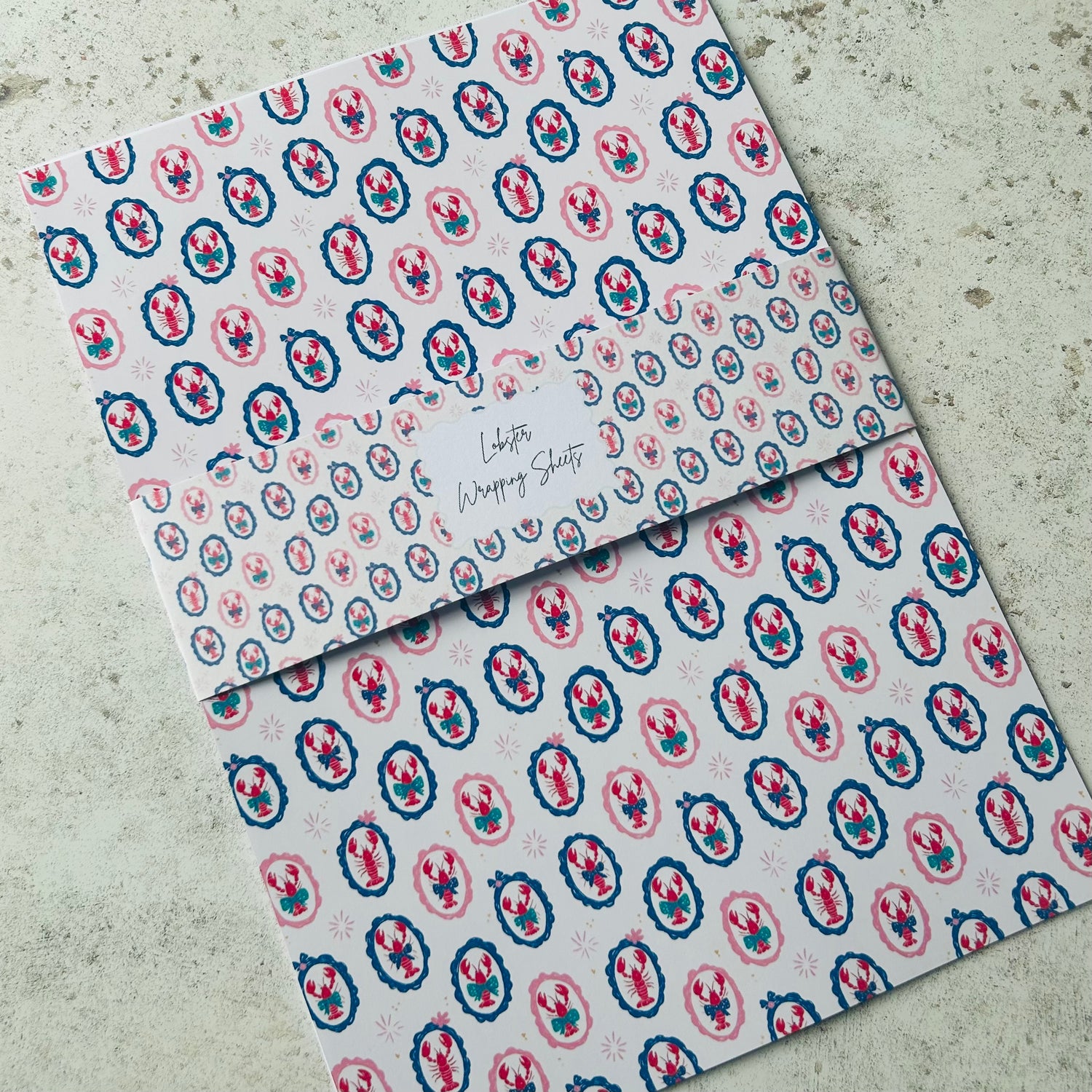 Two patterned lobster a4 sheets on a textured surface