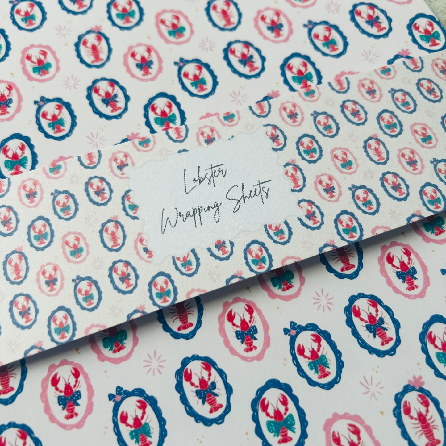 Patterned paper with lobster design and text 'Lobster Wrapping Sheets' on a white background.