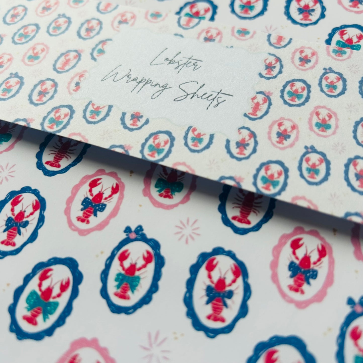 Patterned paper with lobster design and text 'Lobster Wrapping Sheets' on a white background.