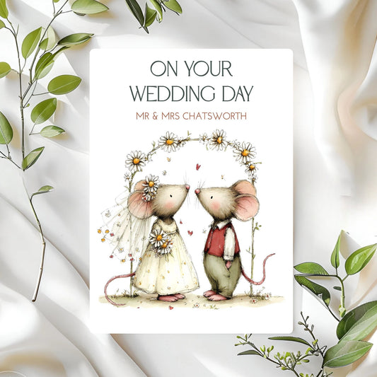 Wedding card with cartoon mice illustration on a white background with green leaves.