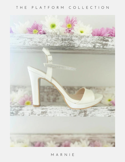 Ivory high-heeled sandal with platform on a decorative surface with flowers, labelled 'Marnie'.