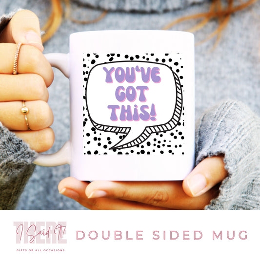 A person holding a white ceramic mug with a double-sided print. The mug has text and dot patterns on it.