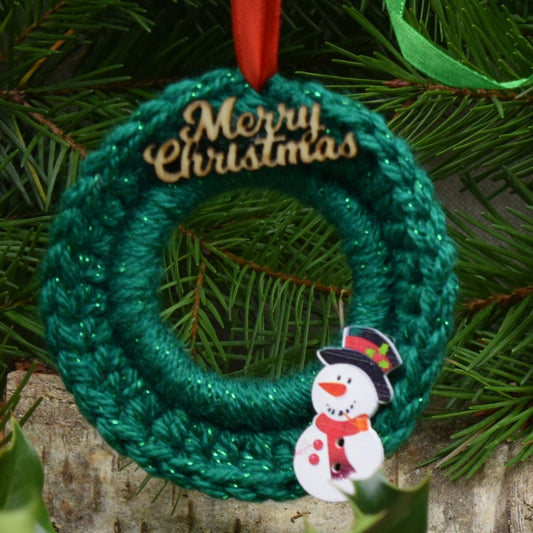 green crochet mini Christmas wreath with cute snowman and Merry Christmas wording