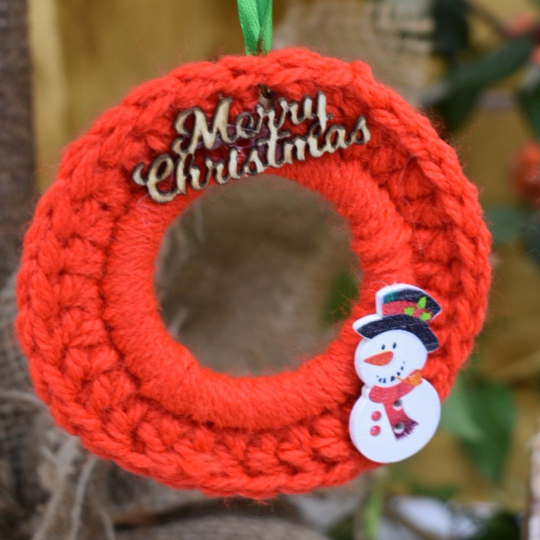 red mini Christmas wreath with Merry Christmas wording and a cute little snowman,