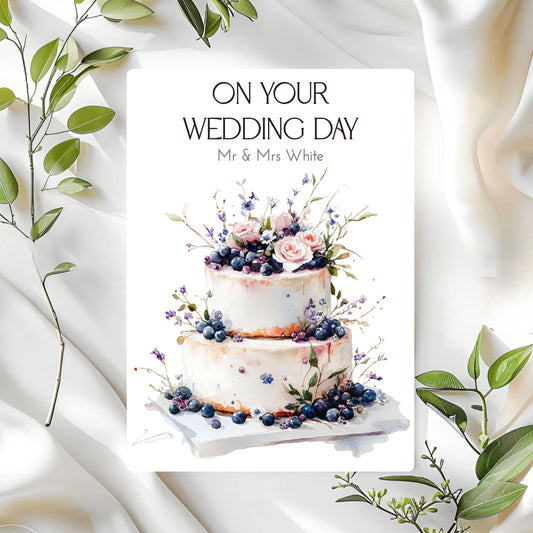 Wedding card with a decorated cake and 'On Your Wedding Day' text on a white background with green leaves.