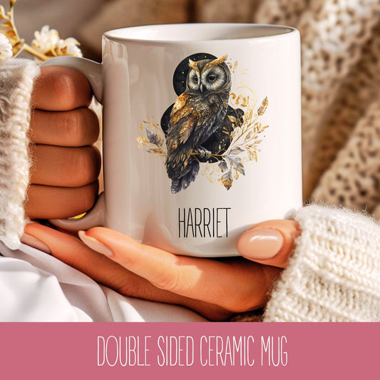 A person holding a white ceramic coffee mug with a brown owl design and the name 'Harriet' printed on it.