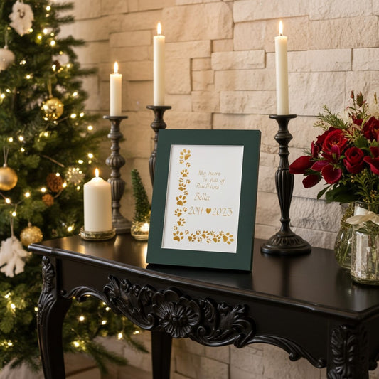 Framed memorial pet painting on a table with candles and a Christmas tree in the background
